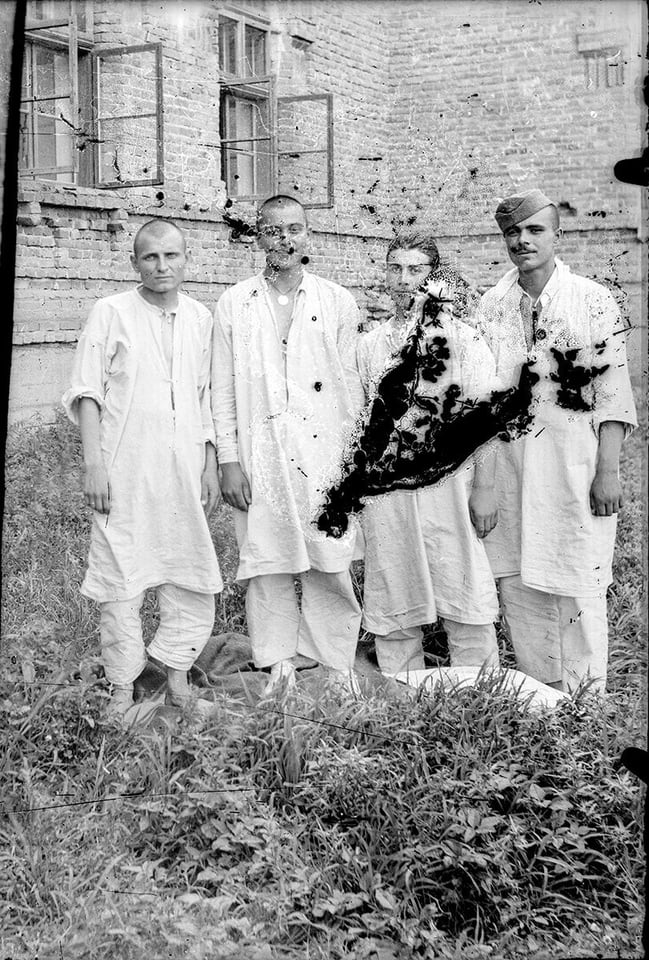 Black-and-white group photo with a large area of lost emulsion